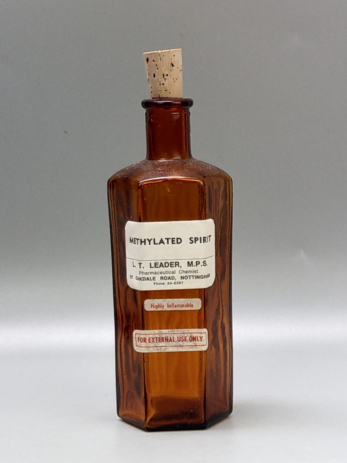 Vintage brown glass chemist bottle with label: Methylated Spirit L.T. Leader